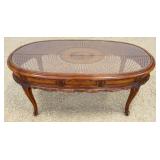 1191	OVAL FRUITWOOD GLASS TOP COFFEE TABLE W/WOVEN CANE UNDER GLASS, APPROXIMATELY 45 IN X 22 IN X 1