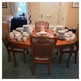 Traditional wood dining table and cane-back chairs with vintage china, cups, saucers and serving pie