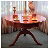 Round wood pedestal table with curved legs, decorative table lamp and colorful Danish cups and sauce