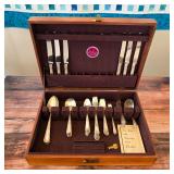 Towle Louis XIV sterling silver flatware with sterling-handled knives, displayed in a wooden flatwar