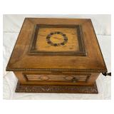  exterior features inlaid decorative patterns and a carved wood base