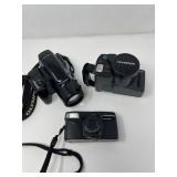 Olympus IS‑2, SuperZoom 300, and Zoom2000 Camera Trio