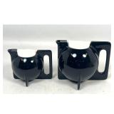 Lot 887  Pair of Modernist Ceramic Black Glazed Teapots with Contrasting White Lids and Fin-Like Bases. Unsig