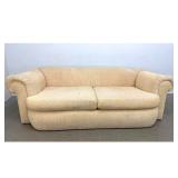 Lot 1211  Postmodern 2 cushion upholstered sofa with rolled arms and ribbed corduroy fabric. 
